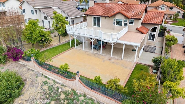 rear view of property featuring fence private yard, stucco siding, a tiled roof, and a residential view