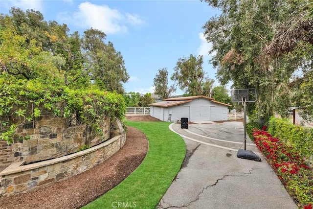 view of side of property with aphalt driveway and fence