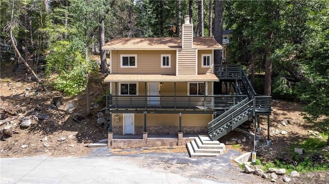 26131 Lake Forest Dr, Twin Peaks, CA 92391 - view of front of house with stairs, a chimney, roof with shingles, and a deck