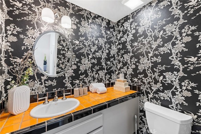 half bathroom with vanity and toilet
