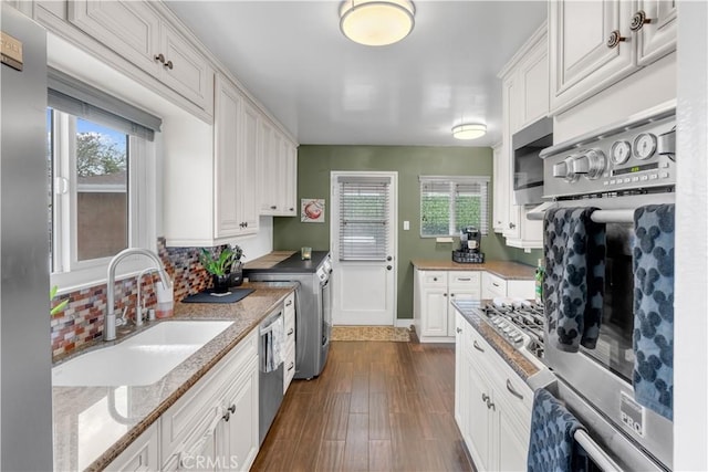 kitchen with a sink, white cabinetry, stainless steel appliances, and a healthy amount of sunlight