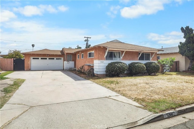 single story home with fence, concrete driveway, a gate, an attached garage, and stucco siding