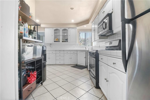 kitchen featuring stainless steel appliances, decorative backsplash, light tile patterned floors, open shelves, and white cabinets