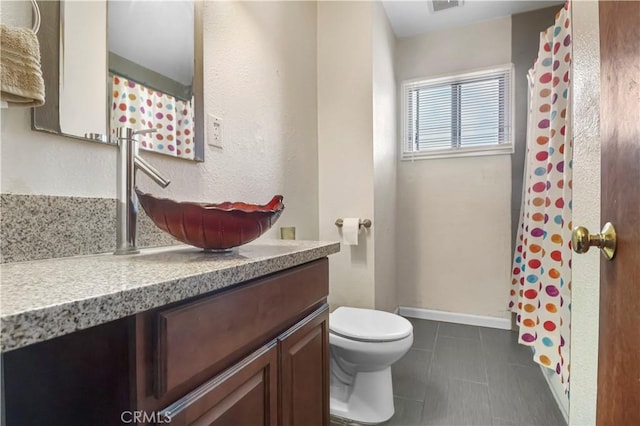 full bath featuring tile patterned floors, toilet, vanity, baseboards, and visible vents