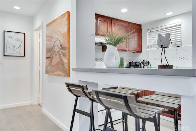 bar featuring recessed lighting, baseboards, backsplash, and light wood-style floors