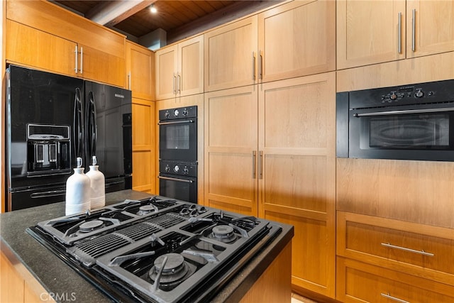 kitchen with beamed ceiling, black appliances, light brown cabinetry, and dark stone countertops