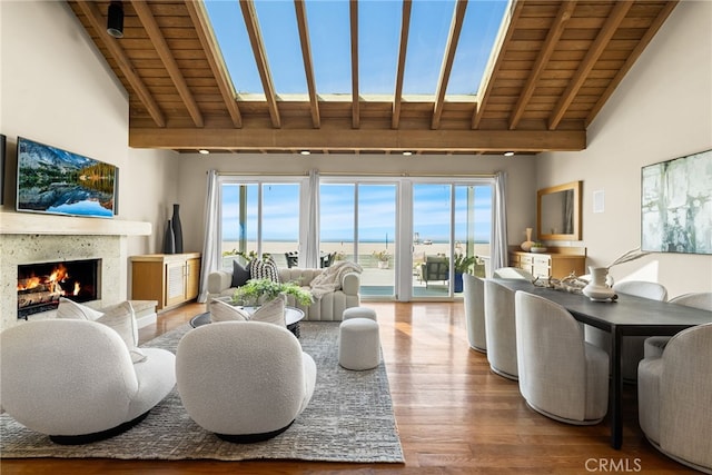 living area featuring beam ceiling, wooden ceiling, and wood finished floors