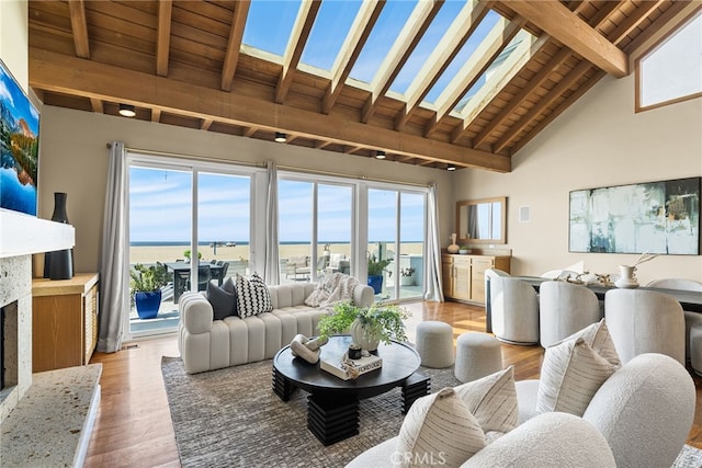 living area featuring beam ceiling, high vaulted ceiling, light wood-style flooring, and wood ceiling