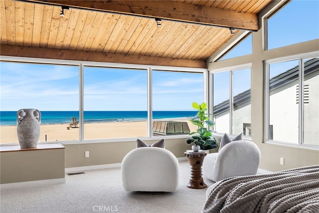 sunroom with visible vents, beamed ceiling, a water view, and a view of the beach