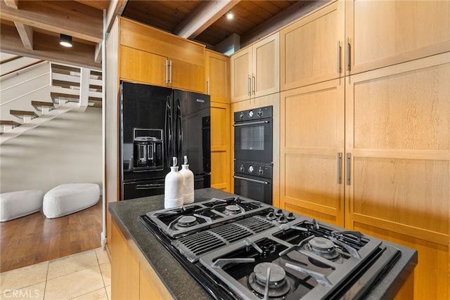kitchen featuring wooden ceiling, beam ceiling, light brown cabinets, light tile patterned floors, and black appliances