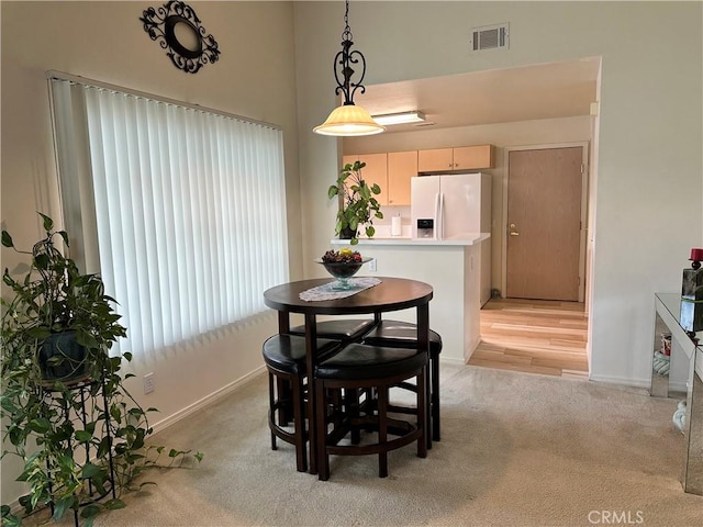 dining space featuring visible vents, baseboards, and light colored carpet