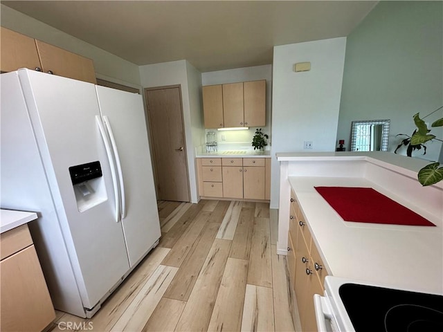 kitchen featuring white appliances, light brown cabinets, light wood finished floors, and light countertops