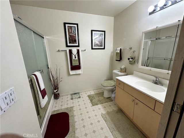 bathroom featuring vanity, toilet, baseboards, tile patterned floors, and a stall shower