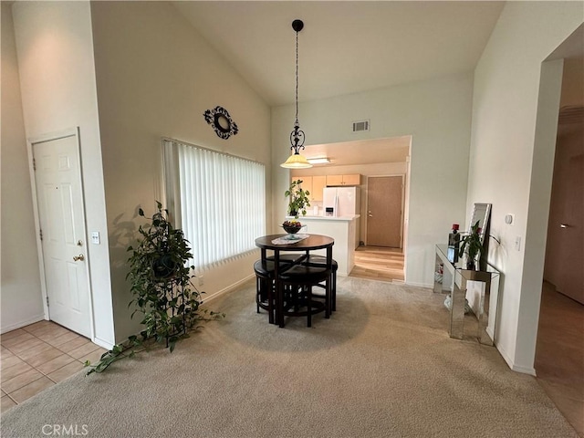 dining room with high vaulted ceiling, visible vents, and baseboards