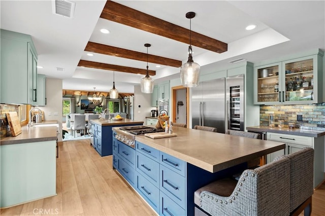 2291 Pavillion Dr, North Tustin, CA 92705 - kitchen with stainless steel appliances, beam ceiling, a large island, visible vents, and backsplash