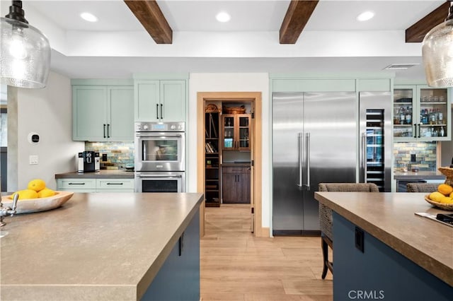 2291 Pavillion Dr, North Tustin, CA 92705 - kitchen featuring beamed ceiling, light wood finished floors, stainless steel appliances, and decorative backsplash