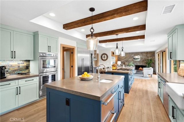 2291 Pavillion Dr, North Tustin, CA 92705 - kitchen with visible vents, a sink, open floor plan, a kitchen island with sink, and a fireplace