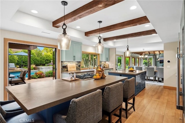 2291 Pavillion Dr, North Tustin, CA 92705 - kitchen featuring an island with sink, blue cabinets, a healthy amount of sunlight, and beam ceiling