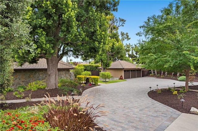2291 Pavillion Dr, North Tustin, CA 92705 - view of front of home with stone siding, a garage, and decorative driveway