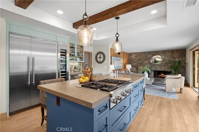 2291 Pavillion Dr, North Tustin, CA 92705 - kitchen featuring light wood finished floors, visible vents, blue cabinets, open floor plan, and stainless steel appliances