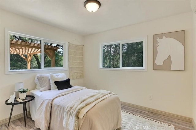 bedroom with baseboards and wood finished floors