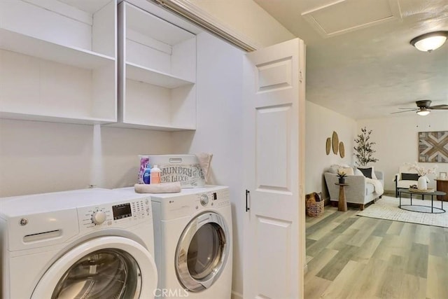 laundry area featuring laundry area, attic access, light wood-type flooring, a ceiling fan, and washer and clothes dryer