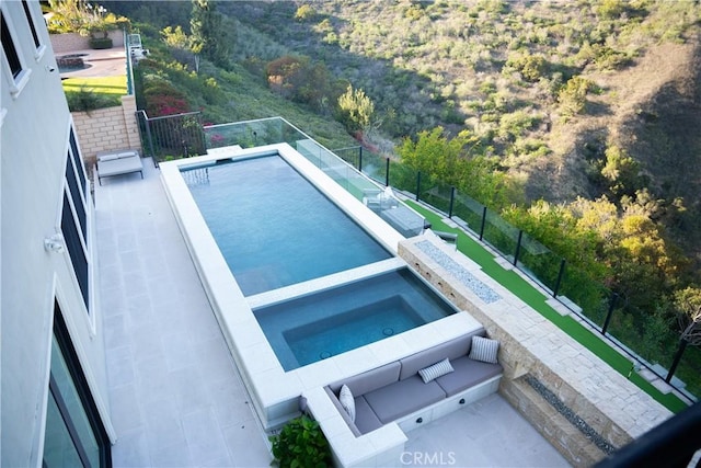 view of swimming pool featuring fence, a fenced in pool, and an in ground hot tub