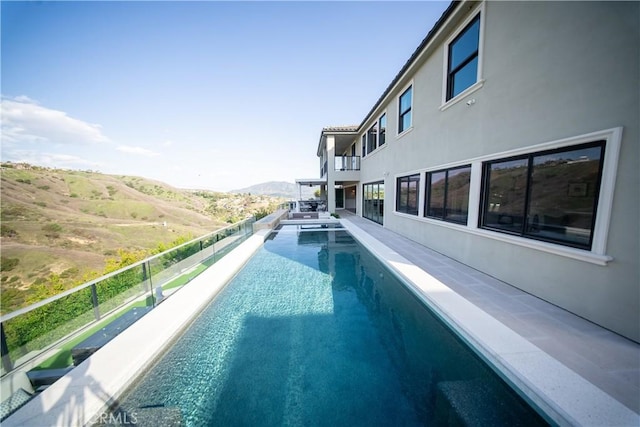 view of swimming pool with a mountain view