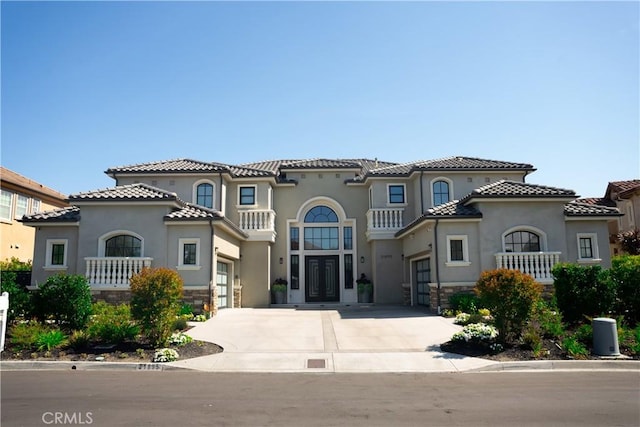 mediterranean / spanish home with french doors, stucco siding, driveway, and a garage