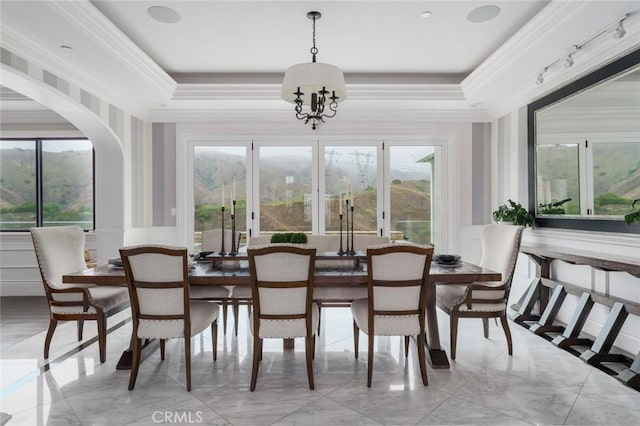 dining space featuring arched walkways, marble finish floor, and a decorative wall