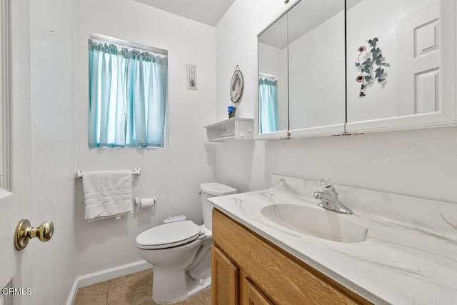 bathroom with baseboards, tile patterned floors, toilet, and vanity