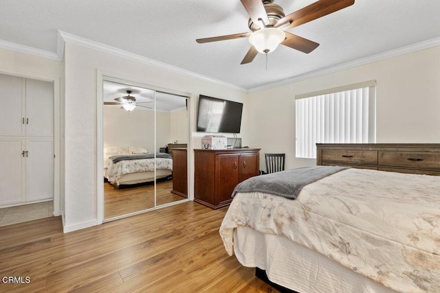 bedroom with a closet, ceiling fan, ornamental molding, and light wood-type flooring