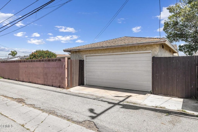 detached garage featuring fence