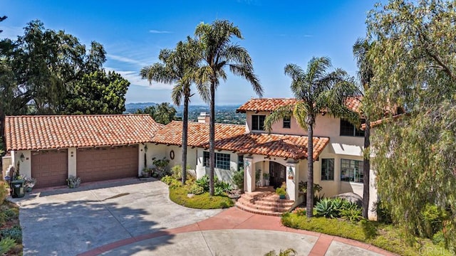 3351 Red Mountain Heights Dr, Fallbrook, CA 92028 - mediterranean / spanish-style house featuring a garage, stucco siding, a chimney, a tiled roof, and driveway