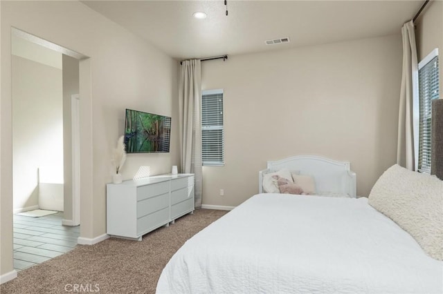 bedroom with baseboards, visible vents, light carpet, and recessed lighting