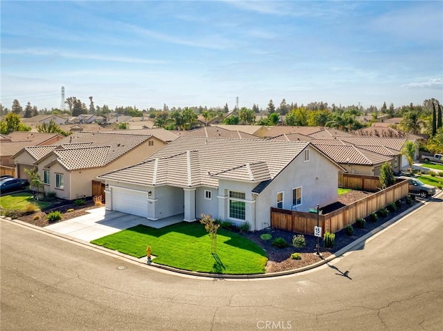 view of front of home featuring a garage, a residential view, driveway, stucco siding, and fence