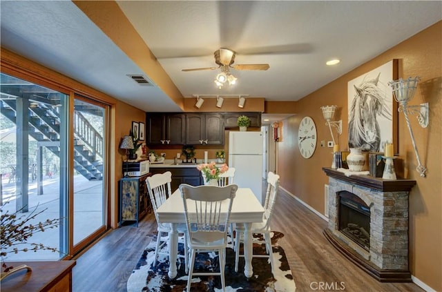 dining room with dark wood-type flooring, visible vents, a ceiling fan, and baseboards