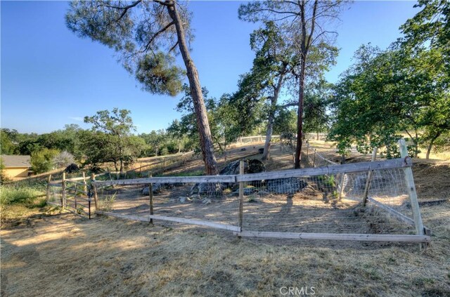 view of yard with fence and a rural view