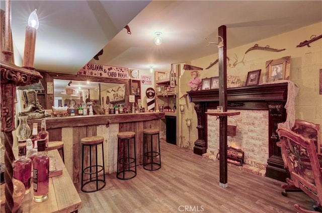 bar with wood finished floors and a bar