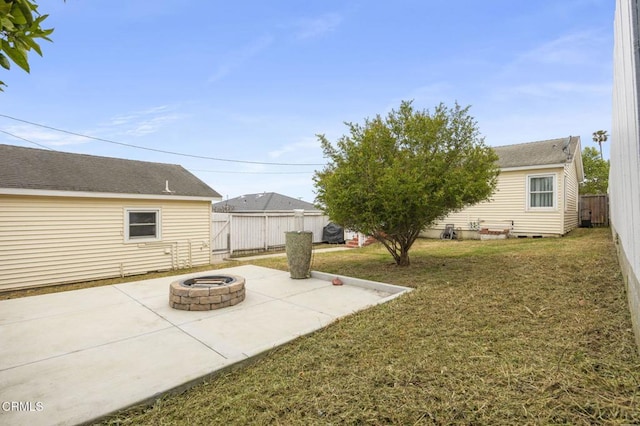 view of yard featuring a fire pit, a patio area, and a fenced backyard