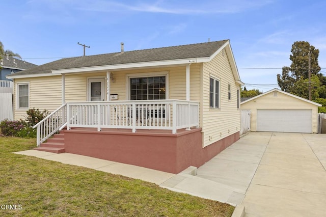 view of front of home featuring covered porch, a detached garage, an outdoor structure, and a front yard