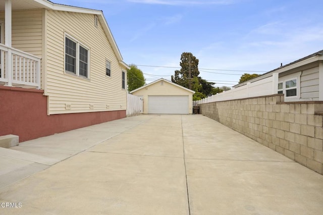 view of home's exterior with an outbuilding, fence, and a garage
