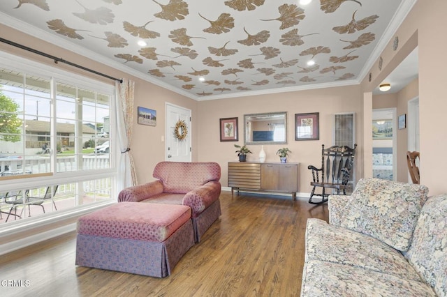 living area with baseboards, a healthy amount of sunlight, crown molding, and wood finished floors