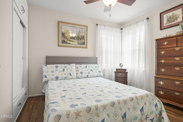 bedroom featuring a closet, dark wood-type flooring, baseboards, and ceiling fan