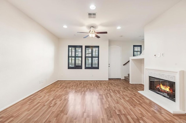 unfurnished living room with visible vents, light wood-style floors, ceiling fan, and baseboards