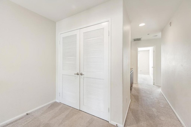 corridor with recessed lighting, baseboards, visible vents, and light carpet