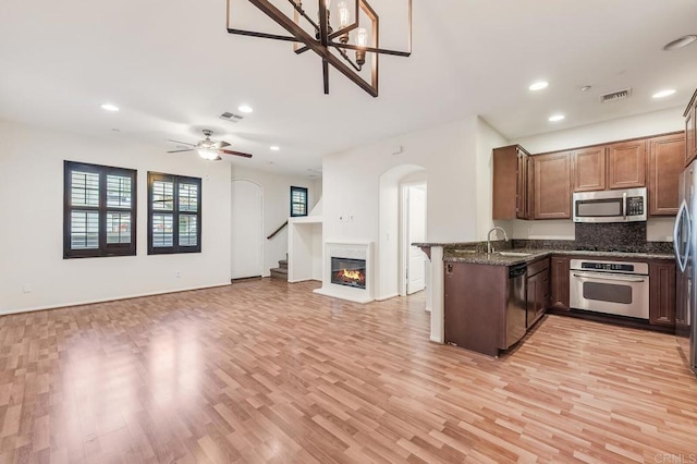kitchen featuring visible vents, arched walkways, a sink, and stainless steel appliances