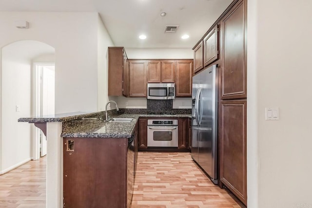 kitchen with visible vents, a sink, light wood-style floors, and stainless steel appliances