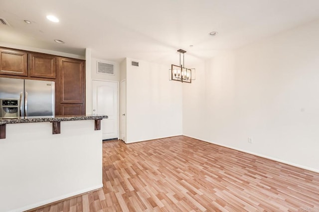kitchen with visible vents, light wood-type flooring, a notable chandelier, and stainless steel fridge with ice dispenser