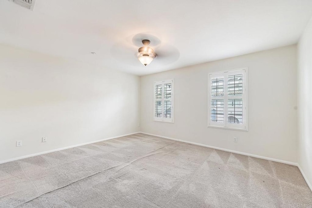 unfurnished room featuring baseboards, ceiling fan, carpet, and visible vents